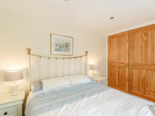 Burgh le MarshにあるOld Foundry Cottageのベッドルーム1室(ベッド1台付)、木製キャビネットが備わります。