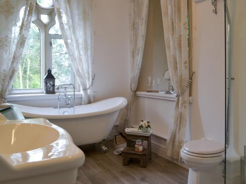 ウィンダミアにあるPriory Manorのバスルーム(バスタブ、洗面台、トイレ付)