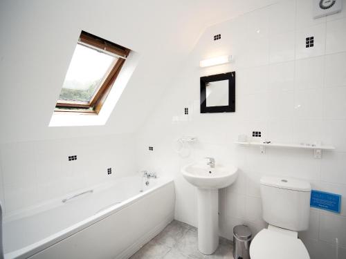 a white bathroom with a sink and a tub and a toilet at Lake View Cottage - Cv7102 in Saint Cleer
