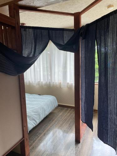 a bedroom with a bunk bed with blue curtains at 金閣莊 private onsen by reservation for free in Hakone