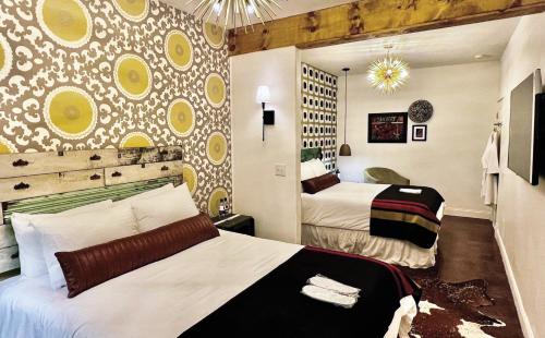 une chambre d'hôtel avec 2 lits et une fresque murale. dans l'établissement Mulberry Inn, à Tishomingo