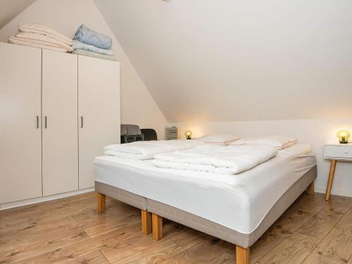Holiday home Tønder IV في توندر: سرير كبير في غرفة بها دواليب بيضاء