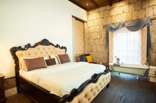 - une chambre avec un lit, une baignoire et une fenêtre dans l'établissement Hotel Vintage "Rialto", à Quetzaltenango