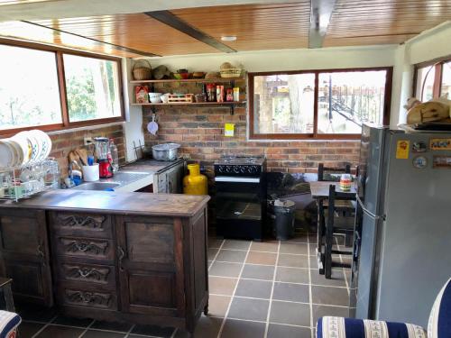 a kitchen with a refrigerator and a table in it at Cabaña Campestre - Ciudad Memoria in Sogamoso