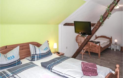 a bedroom with two beds and a tv on a ladder at Am Moor in Achtrup