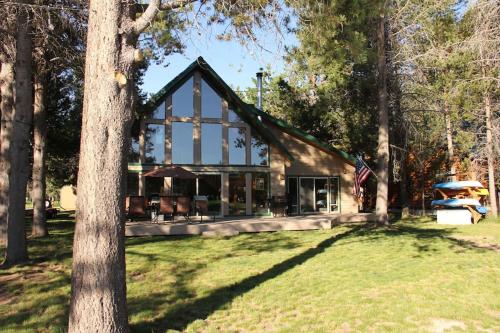 une maison avec drapeau dans les bois dans l'établissement Mt. Bachelor & Sun River Get Away, à Bend