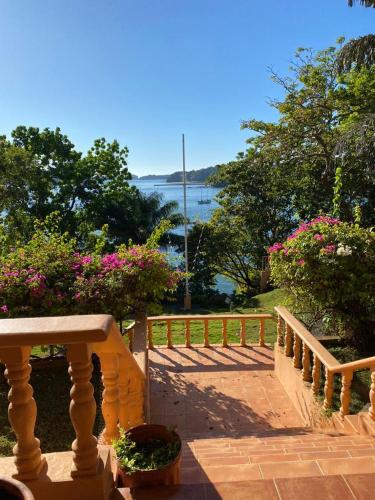 a balcony with a view of the water and flowers at Gone Fishing Panama Resort in Boca Chica