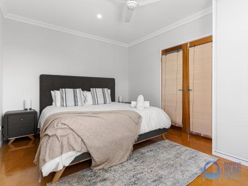 a white bedroom with a large bed and a rug at Rest & Recharge in Bouvard in Dawesville