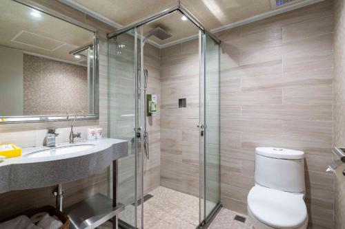 a bathroom with a shower and a toilet and a sink at The Cloud Hotel in Taichung