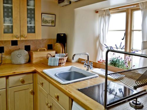 a kitchen counter with a sink and a window at Cribba in Wadebridge