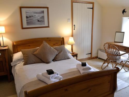 a bedroom with a bed with two cell phones on it at Cribba in Wadebridge