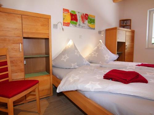 a bedroom with a bed and a red chair at Doppelhaushälfte Lee in Zingst in Zingst