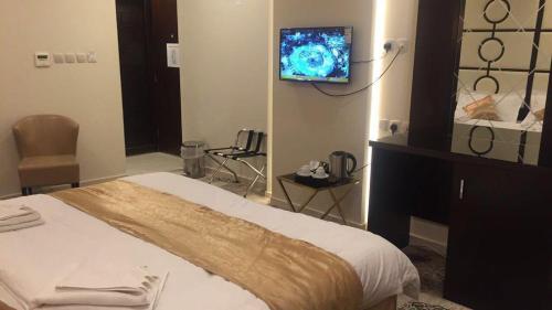 a hotel room with a bed and a tv on the wall at فندق البيرق in Makkah