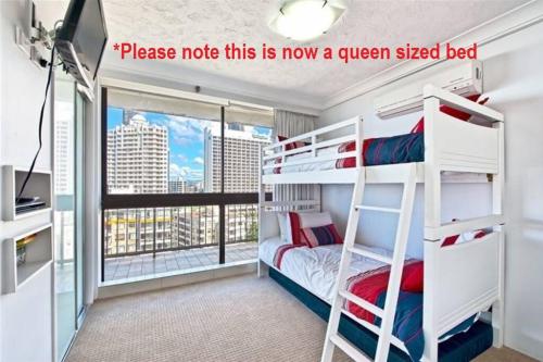 a bedroom with bunk beds with a view of a city at Surfers Paradise Apartment With Amazing Views in Gold Coast