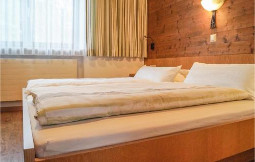 een bed in een slaapkamer met een houten muur bij Amazing Apartment In Niederau With House A Mountain View in Niederau