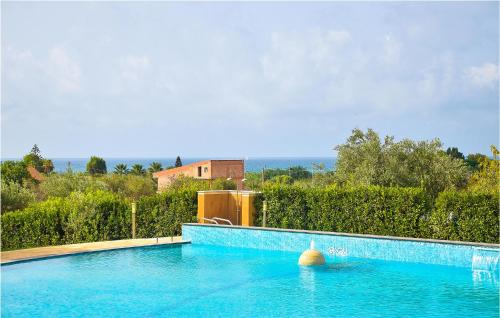 a large blue swimming pool in front of a fence at Beautiful Home In Pozzallo Rg in Pozzallo