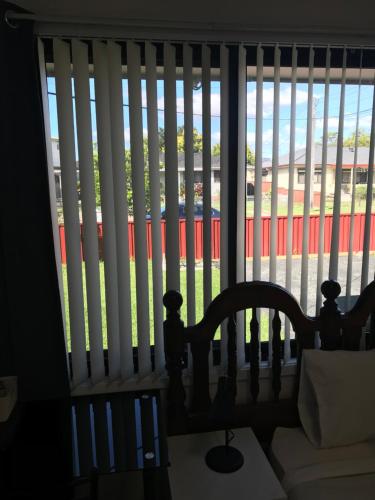 a room with a window with vertical blinds at Fragrant Home-68C one king single bed aircon Room in Doonside