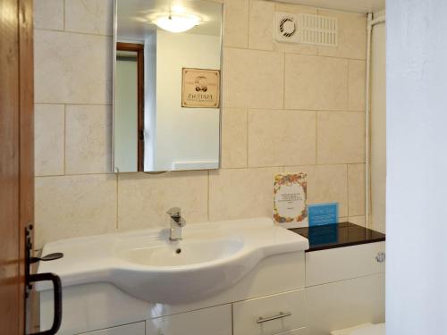 a bathroom with a white sink and a mirror at Ganny Cottage - Lzl in Eskdale