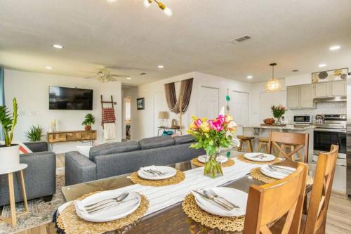 a dining room and living room with a table and a couch at Woodsy Retreat, steps to Bay - Hot tub! in Gulf Breeze