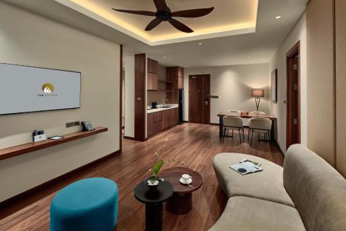 uma sala de estar com um sofá e uma ventoinha de tecto em The Watson Premium HaLong Hotel em Ha Long