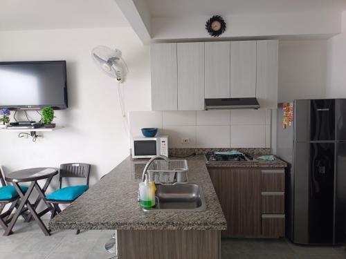 uma cozinha com um lavatório e uma bancada em AQUAVALE - Apartamento Vacacional en Girardot em Girardot