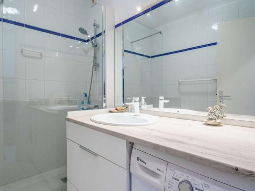 une salle de bain blanche avec un lavabo et un miroir dans l'établissement Appartement lumineux au port de plaisance, à 200m de la plage avec parking et commerces à proximité - FR-1-2-425, à Hendaye
