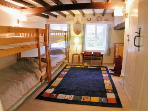 a room with two bunk beds and a rug at Junipers - 28180 in Puncknowle