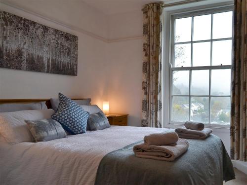 a bedroom with a bed with towels on it at Ellerview House in Ambleside