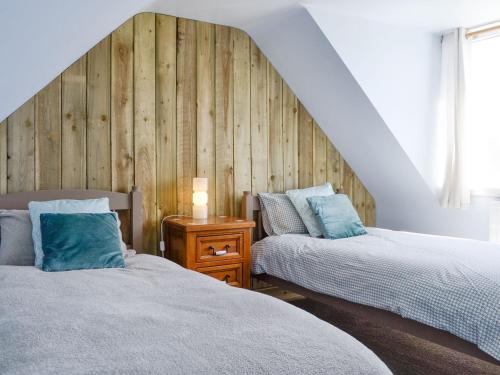 two beds sitting next to each other in a bedroom at South Cross Slacks Farmhouse in Crovie