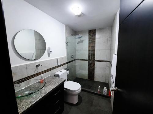 y baño con aseo, lavabo y espejo. en Departamento de lujo Condominio ADMIRA, en Cuenca