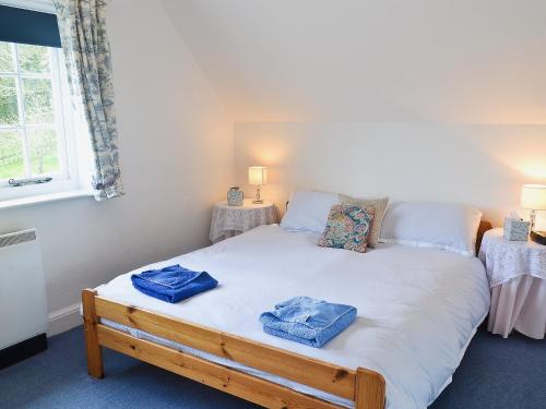 a bedroom with a bed with two towels on it at Keepers Cottage in Helford Passage