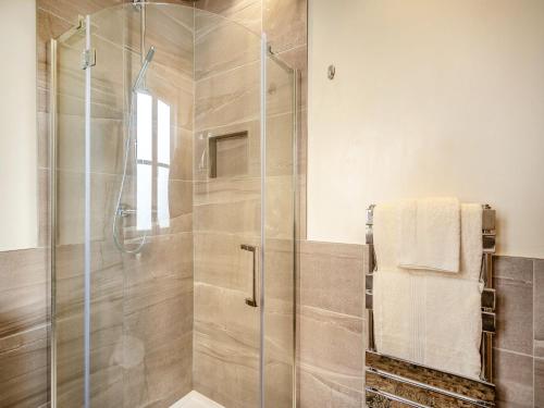 een badkamer met een douche en een glazen deur bij Lavender Cottage - Uk38682 in Oxhill