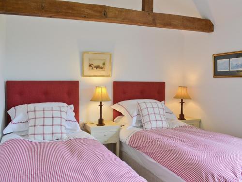 two beds sitting next to each other in a bedroom at Priory Barn in Weald