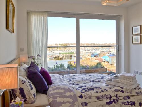 a bedroom with a bed and a large window at The Barnacle in Oulton