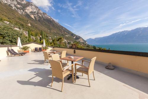 a table and chairs on a balcony with a view of the ocean at Hotel Meandro - Lake View in Gargnano