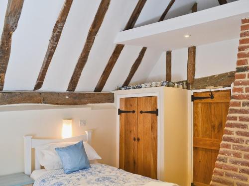 Schlafzimmer mit einem Bett und einer Holztür in der Unterkunft Walnut Cottage in Sproughton