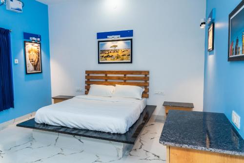 um quarto com uma cama e paredes azuis em Panism Lifestyle em Auroville