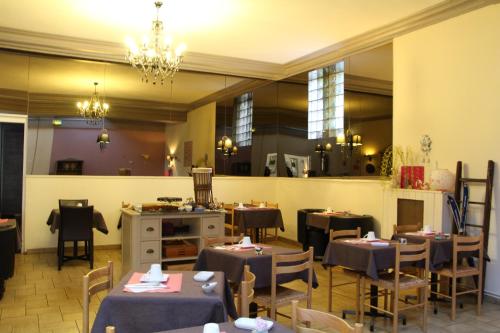 ein Restaurant mit Tischen und Stühlen in einem Zimmer in der Unterkunft Hotel Le Colibri in Aix-les-Bains