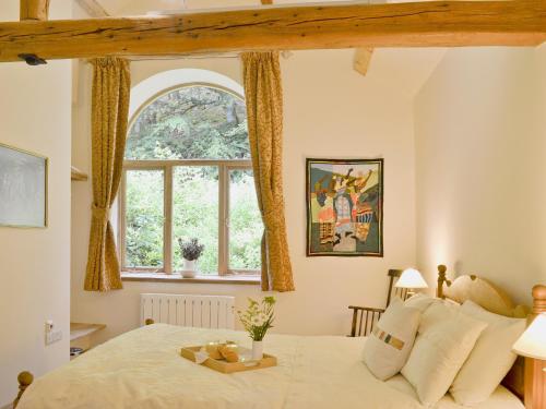 a bedroom with a large bed with a window at Pendre Isaf in Pentre-briwnant
