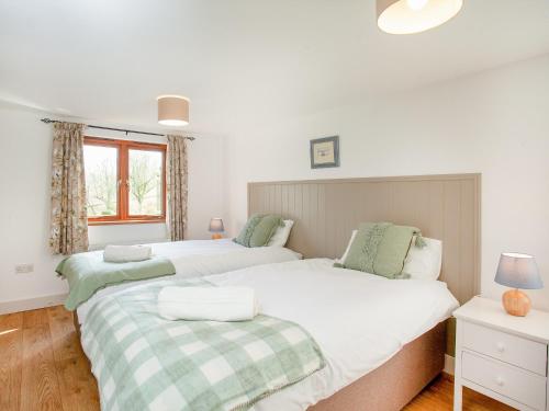 a bedroom with two beds and a window at Cowslip Cottage in Templeton