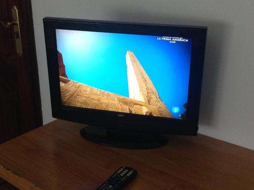 a television with a picture of a boat on the screen at Pensión Glorioso II in Picaraña