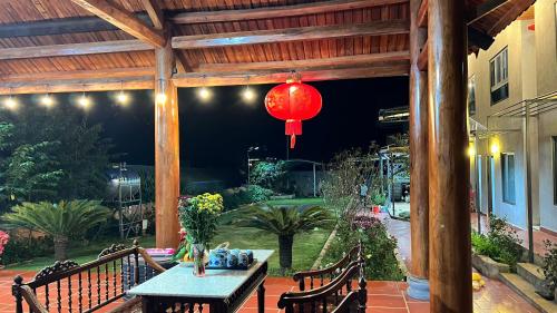 a patio with a table and a red lantern at Homestay Nhà Hí in Ðinh An (2)