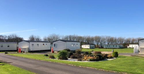 una fila de casas móviles al lado de una carretera en Turnberry Holiday Home en Turnberry