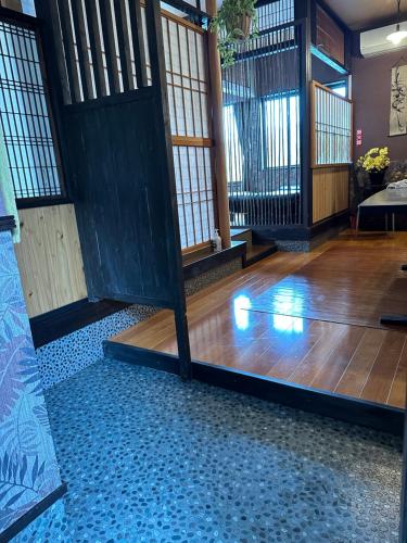 a room with a wooden floor and a wooden door at ゲストハウス れんげ苑 in Shimosato