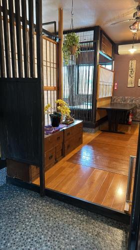 a room with a wooden floor and a wooden door at ゲストハウス れんげ苑 in Shimosato