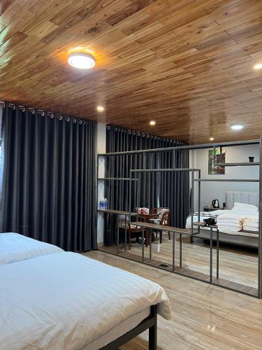 a bedroom with two beds and a table in a room at Homestay Nhà Hí in Ðinh An (2)
