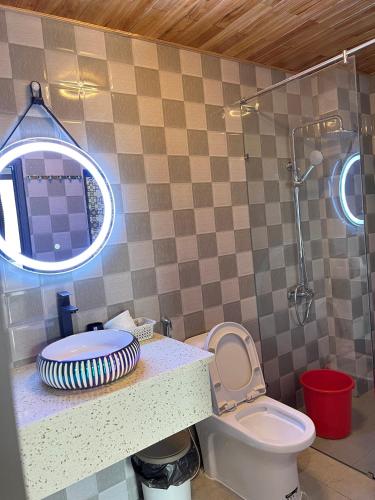 a bathroom with a sink and a toilet and a shower at Homestay Nhà Hí in Ðinh An (2)