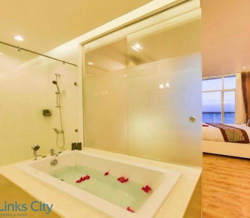 y baño con bañera con flores rojas. en Sea View Condo, en Phan Thiet