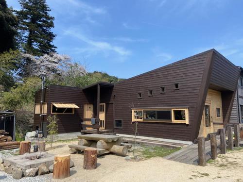 ein großes Holzhaus mit einem Picknicktisch davor in der Unterkunft 玄か~sizuka~ 