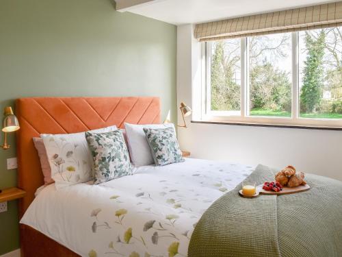Fuggle في Ludham: غرفة نوم مع سرير مع طبق من الطعام عليه